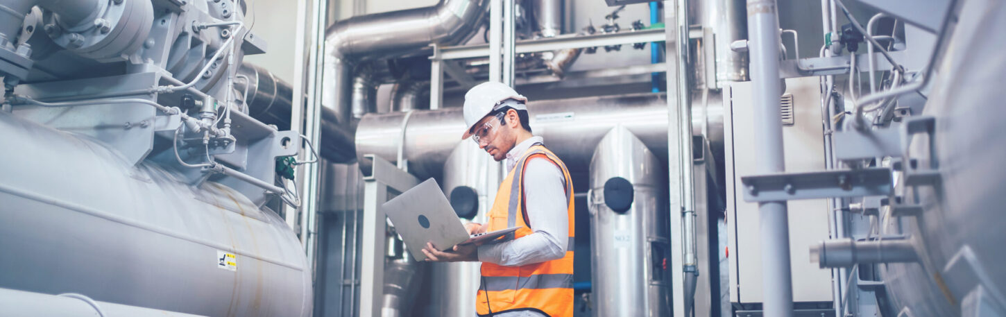 professional-worker-of-modern-factory-using-laptop-controlling-p